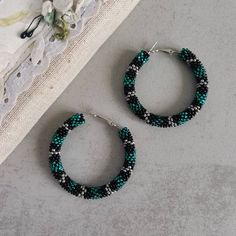 These sculptural thick beadwork hoops in discreet green, silver and black color combination look like grinning snake skin. If you love bohemian or ethnic style jewelry, but at the same time prefer sober shades, thay may be your choice. These big statement circle earrings, a perfect specimen of boho jewelry, are beaded of high quality seed beads, are light and comfortable to wear, so you can use them as your everyday casual accessories with no discomfort. ♥ SIZE Approximately 2.2"  ♥ 100% handmade ♥ Packed in a gift box ♥ Very light ♥ If you want this item in a different color, send me a message, please. Feel free to communicate with me. You can see more hoop earrings here: https://etsy.me/2ANdatu Advice on use and care: * Do not wear while bathing or showering. Chlorine can cause damage. * Adjustable Green Hoop Jewelry, Unique Beaded Hoop Jewelry, Green Bohemian Hoop Jewelry, Bohemian Green Hoop Jewelry, Green Circle Bohemian Jewelry, Green Bohemian Circular Jewelry, Bohemian Green Circular Jewelry, Hoop Earrings With Spacer Beads As Gift, Hoop Earrings With Spacer Beads For Gifts