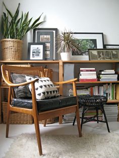 a living room filled with lots of furniture and plants on top of a book shelf