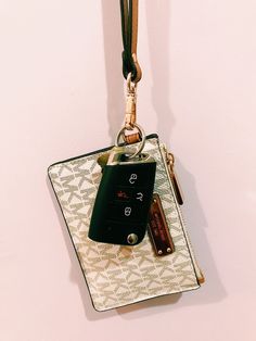 a cell phone hanging on a keychain attached to a wall with a lanyard