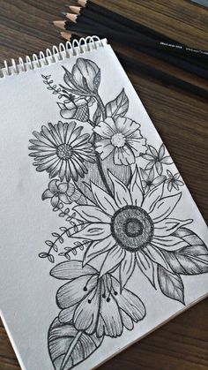 a drawing of flowers on paper with pencils next to it