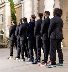 a group of people in suits standing next to each other with shoes on their feet