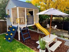 there is a small play house with a slide in the back yard, and an umbrella over it