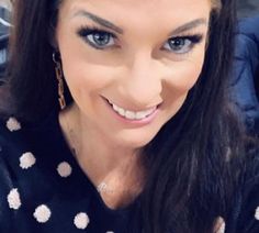 a close up of a person wearing a polka dot shirt and smiling at the camera