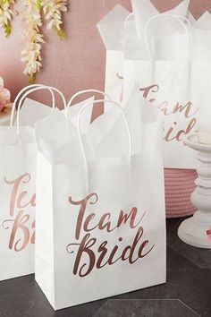 three white paper bags with the words team bride printed on them, sitting next to each other