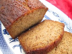 three slices of banana bread on a blue and white plate next to a red cloth