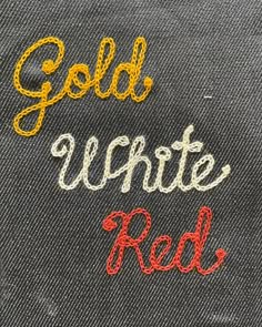 the words gold, white and red are embroidered onto jeans