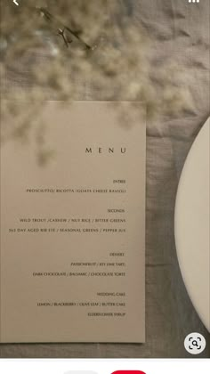 the menu card is next to a plate with a fork and knife on it, along with an empty piece of paper