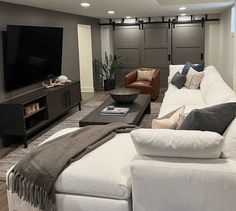 a living room filled with furniture and a flat screen tv on top of a wall