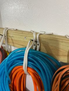 several different colored hoses hanging on a wall