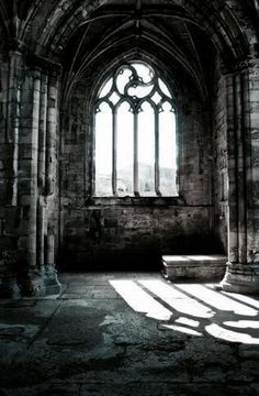 the sunlight is shining in an old building with stone columns and arched glass windows on each side