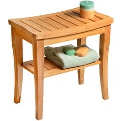 a wooden table with towels and soaps on the top, next to a candle