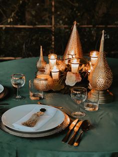 a table set with candles, plates and silverware