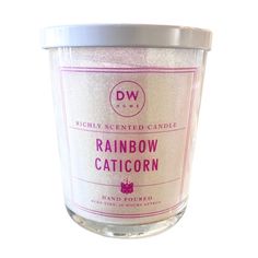 a candle that is sitting on top of a white tablecloth with the words rainbow caticorn printed on it