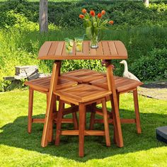 a wooden table and chairs sitting on top of grass covered ground next to a duck