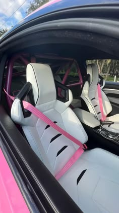 the interior of a car with pink and white leather trims, steering wheel covers and seats