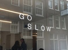 people are standing in front of a window that says go slow