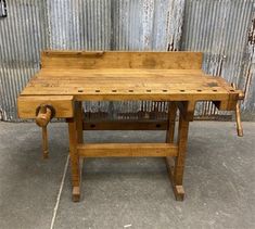 an old wooden workbench sitting in front of a metal wall