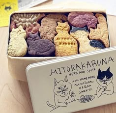 a box filled with different types of cookies on top of a wooden table next to other items