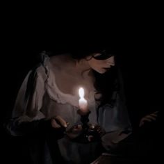 a woman holding a candle in her hands with the light shining down on her face