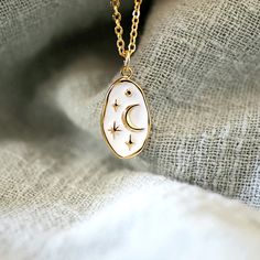 "Beautiful and lovely dainty oval charm necklace. Made of the moon and star white enamel oval shape charm with skinny gold plated brass chain. Soft and warm. The necklace is good for yourself or gift! Your necklace will ship in a gift box. ♥ Chain length 14\"-20\" ♥ Dainty oval charm approx. 1/2\" x 3/4\" ♥ Gold plated over brass ♥ See more Rudiana Accessories Rudiana.etsy.com" Moon Charm Necklace, Oval Necklace With Moon Charm As Gift, White Moon Charm Necklaces As A Gift, Oval Moon Charm Necklace As Gift, White Oval Necklace With Delicate Chain, Gold Necklace With Moon Charm, Oval Moon Charm Necklace Gift, White Celestial Charm Necklace As Gift, White Star Charm Necklace For Gifting