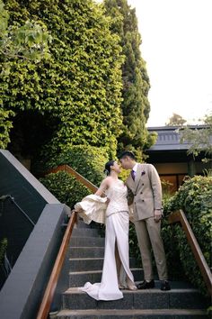 a bride and groom are standing on the stairs