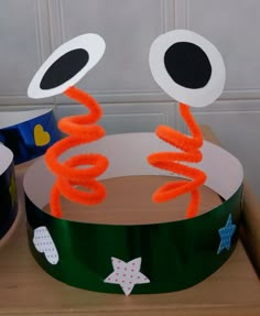 a paper crown with an eyeball and stars on it sitting on top of a wooden table