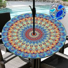 an umbrella sitting on top of a table next to a pool