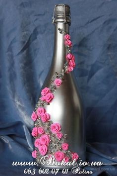 a silver bottle with pink flowers on it