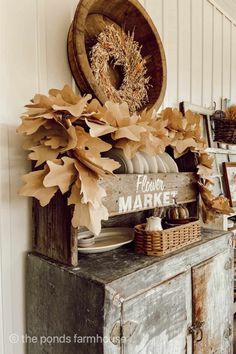 an old dresser with fall decorations on top