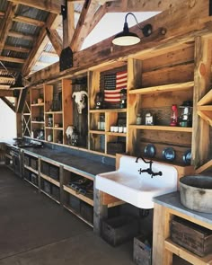 an old fashioned kitchen with wooden shelves and sinks in the center is filled with items