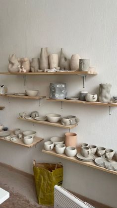 the shelves are filled with pottery and bowls