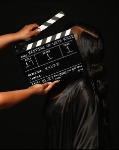 a woman holding a clapper over her face