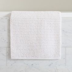 a white towel hanging on the side of a wall