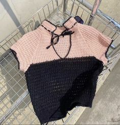 a pink and black sweater sitting on top of a shopping cart