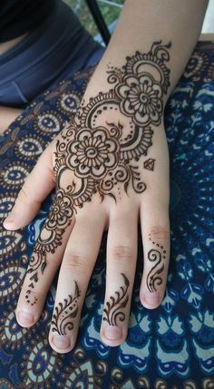 a woman's hand with henna tattoos on it