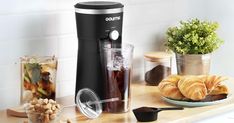 a coffee maker sitting on top of a counter next to some croissants