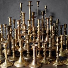 a large collection of brass candlesticks on display