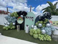 star wars balloon decorations are displayed on the grass at an outdoor event with baby yoda and bbq signs