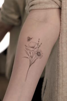 a woman's arm with a flower tattoo on the left side of her arm