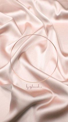 a close up view of a pink satin with a circular frame on it's surface