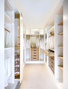 a walk in closet with white walls and drawers