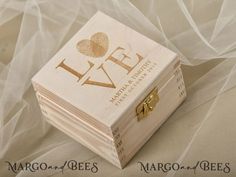 a wooden box with the word love written on it sitting on top of a white cloth