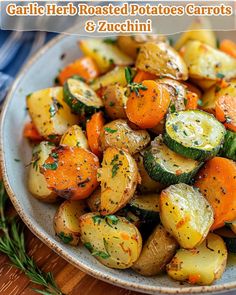 garlic herb roasted potatoes carrots and zucchini on a plate with rosemary garnish