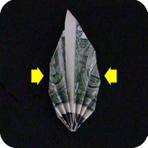 an origami airplane made out of dollar bills on top of a black circle