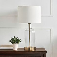 a table with a lamp and a potted plant on it