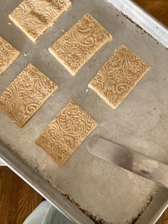 four squares of food on a pan with a spatula in the middle and six square pieces cut out