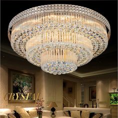 a large crystal chandelier hanging from the ceiling in a living room with couches