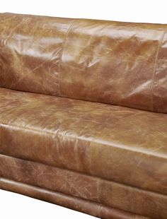 a brown leather couch sitting on top of a wooden table