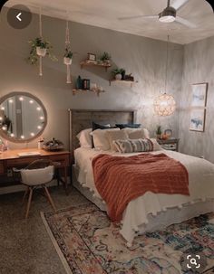 a bed room with a neatly made bed next to a desk and mirror on the wall