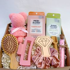 a pink teddy bear sitting in a box filled with beauty products and personal care items